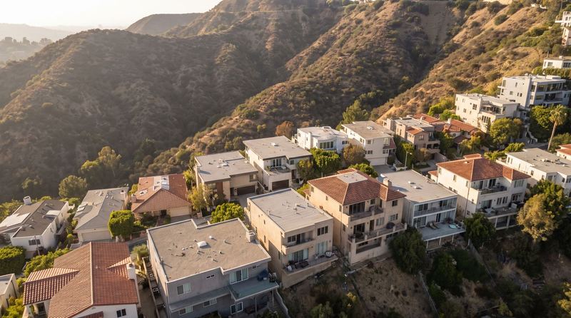 Houses stepped down a Hollywood Hills canyon with flat and tile roofs