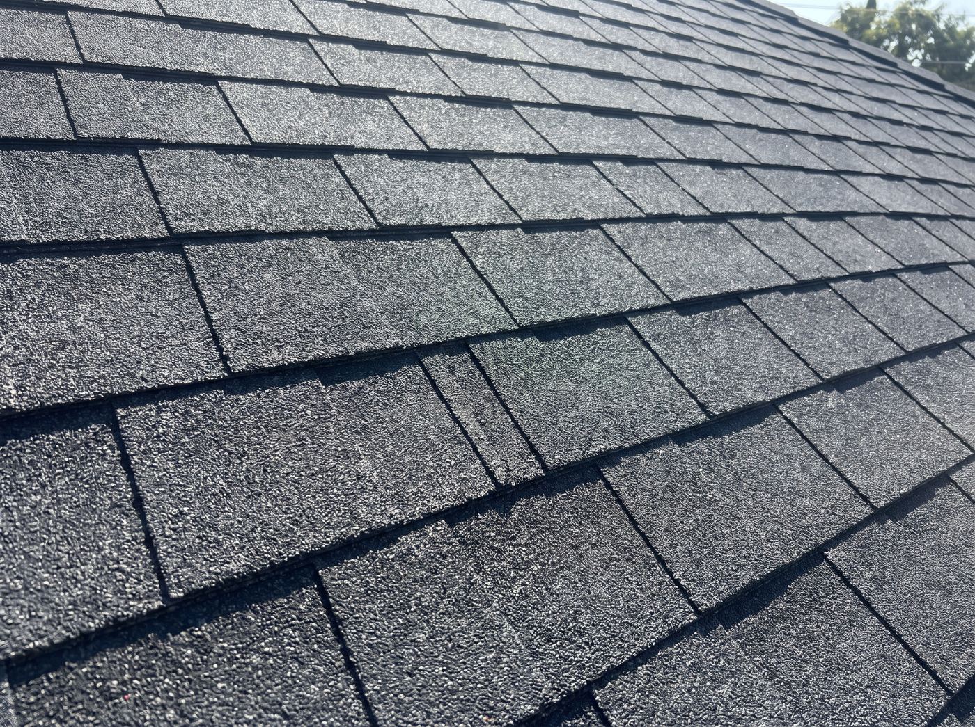 Newly laid charcoal composition shingles in even overlapping courses